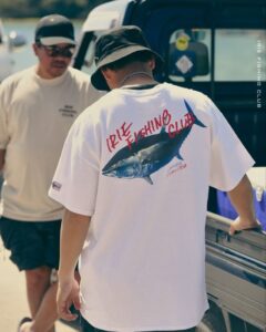 Fisherman-style tee with coastal outfit flatlay – 2025 POD fashion trend